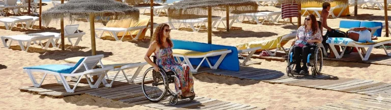 Turismo inclusivo e Praia Acessível em Quarteira com utilizadoras de cadeira de rodas no passadiço.