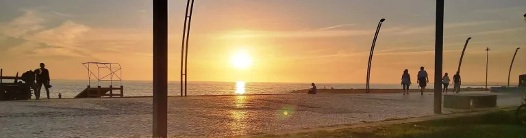 Passeio marítimo em Quarteira com pôr do sol sobre o mar para férias relaxantes no Algarve perto de Vilamoura.