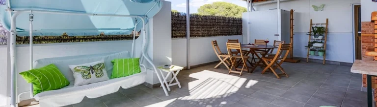 Terraço privativo do Bambus House Green, em Quarteira com baloiço e zona de refeições para férias em família no Algarve em apartamento.