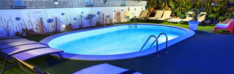 Piscina de água salgada iluminada à noite na melhor zona para ficar em Quarteira na Bambus House Holidays Rental.